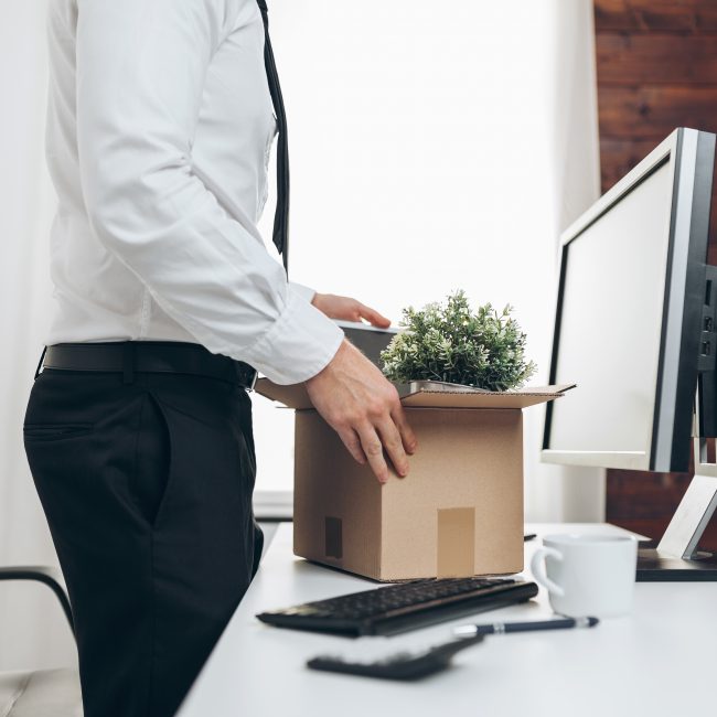 Ein Mann, der aus dem Büro umzieht und seinen Platz räumt
