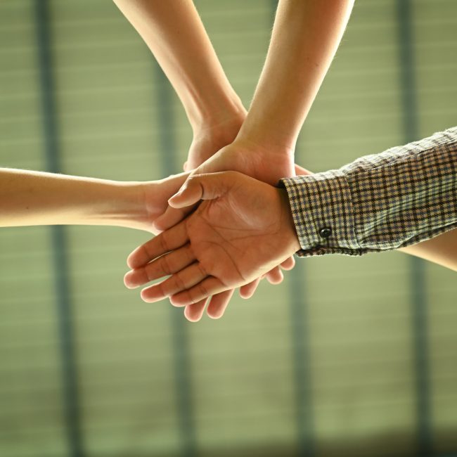 Teamzusammenhalt - mehrere Hände, die einschlagen